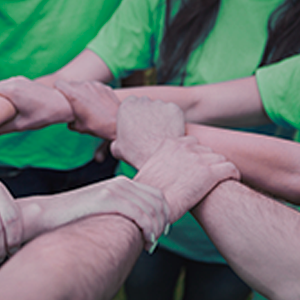 Fons de solidaritat- Personas agarradas de la mano con camiseta verde