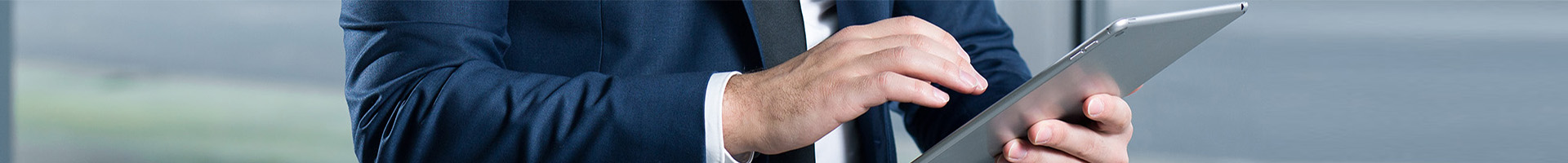 Informe de mercados y carteras - Hombre de negocios con traje de color azul y camisa blanca buscando informes de mercados y carteras en su tablet Informe de mercados y carteras - Hombre de negocios con traje de color azul y camisa blanca buscando informes de mercados y carteras en su tablet