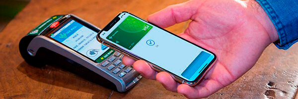 Apple Pay - Persona pagando con apple pay en su movil en el tpv de un comercio