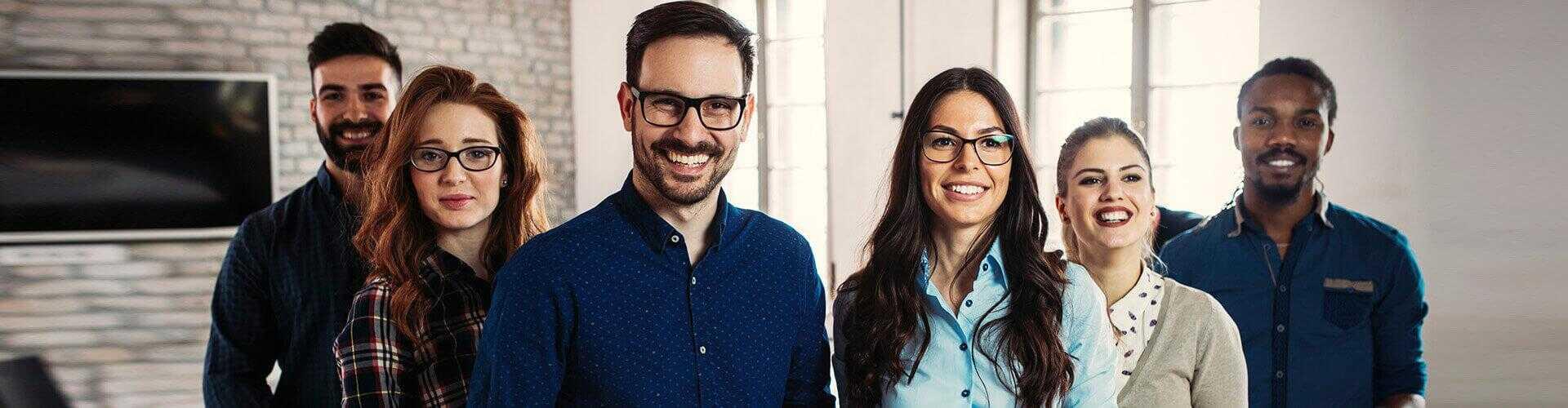 Programa-Porque-somos-asi-cabecera-grupo-personas-en-fila-sonriendo-unas-al-lado-de-otras-en-oficina