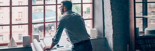 Anticipo de Exportaciones para empresas - Un hombre de negocios mirando por la ventana